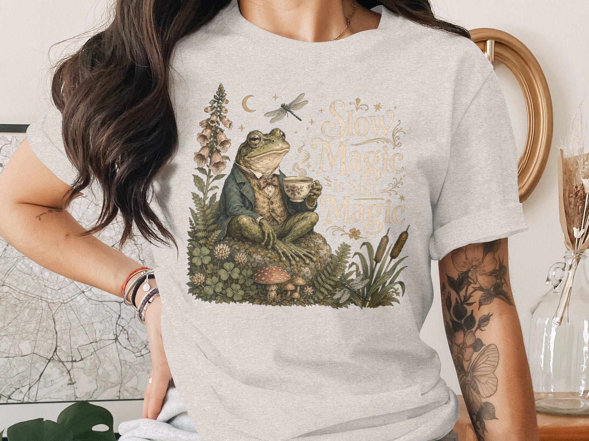 A frog in a suit sips tea next to plants and text that reads "Slow Magic."