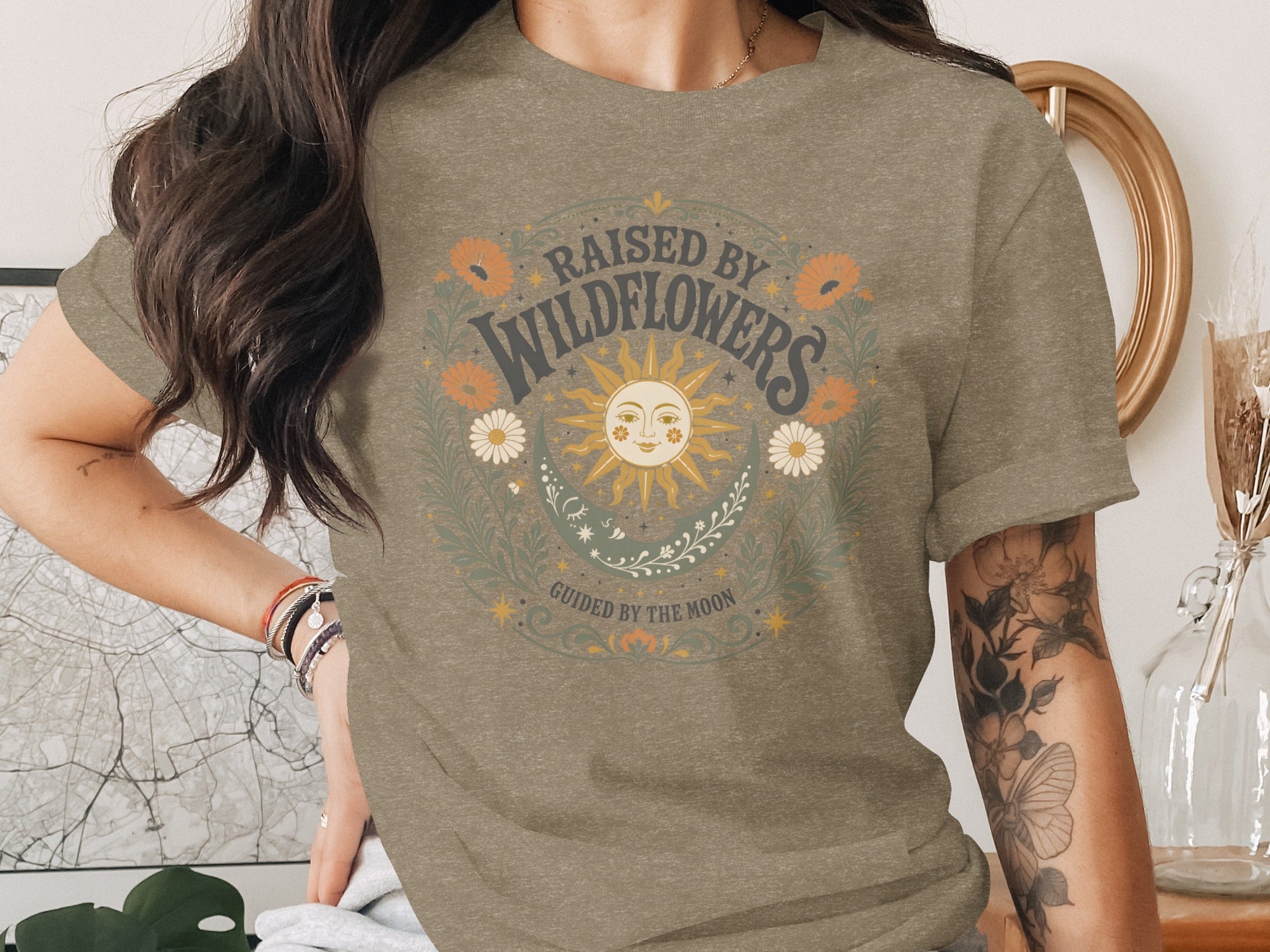 T-shirt with "Raised by Wildflowers" and a sun graphic with "Guided by the Moon".