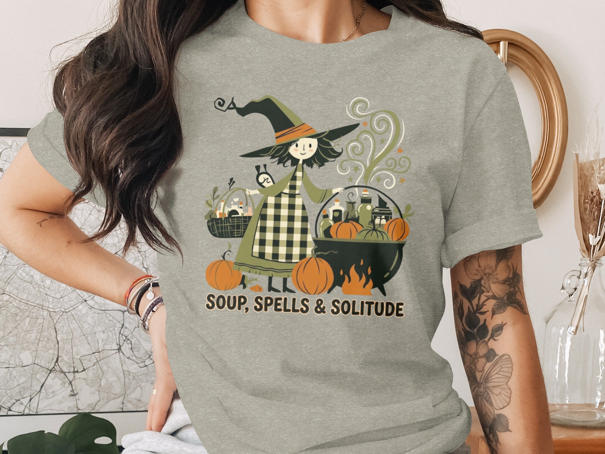 Brown-haired witch with pumpkins and cauldron graphic text "SOUP, SPELLS & SOLITUDE"