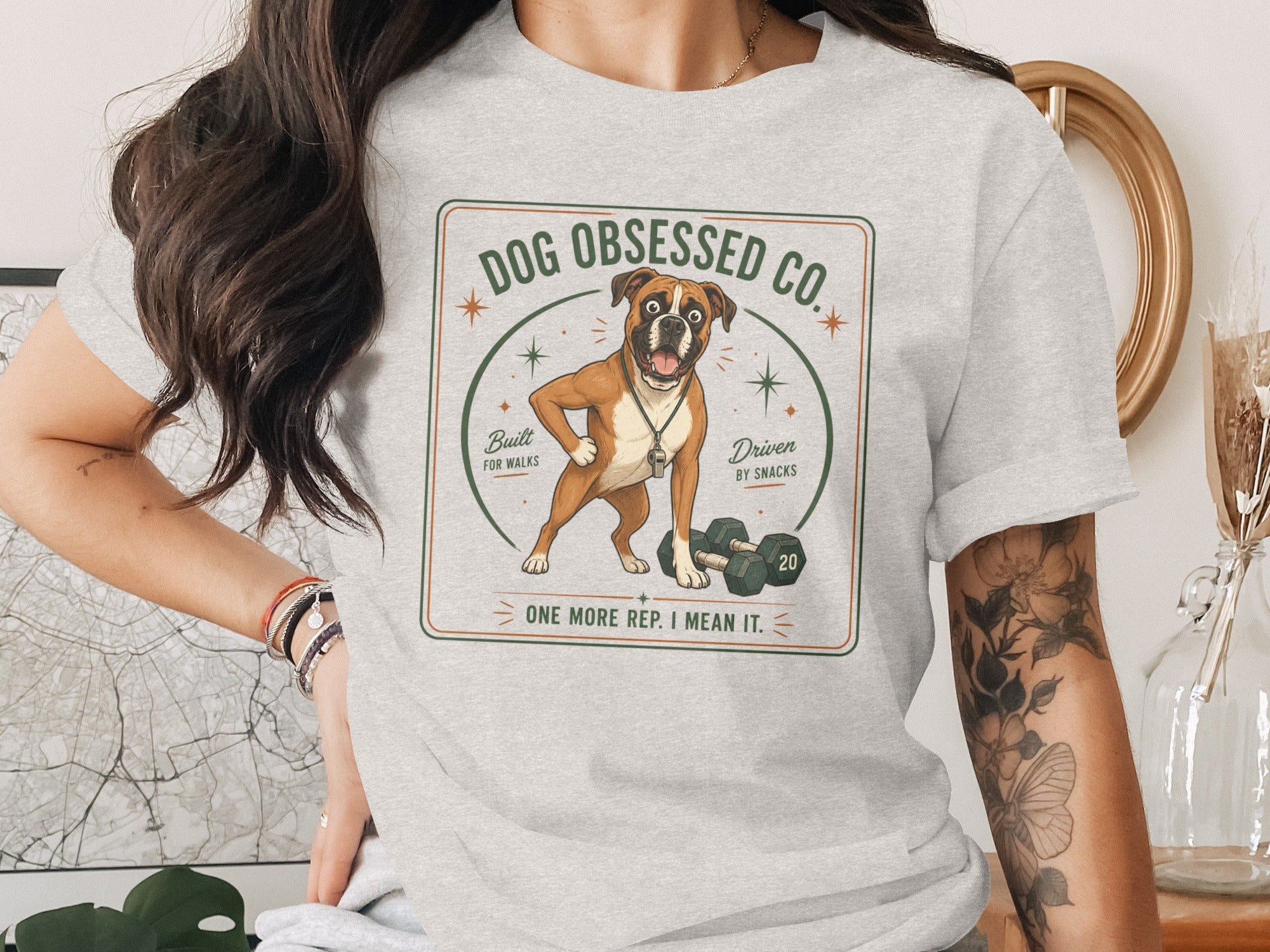 Grey t-shirt with a boxer dog graphic, dumbbells, and text: "DOG OBSESSED CO. Built FOR WALKS Driven BY SNACKS ONE MORE REP. I MEAN IT."