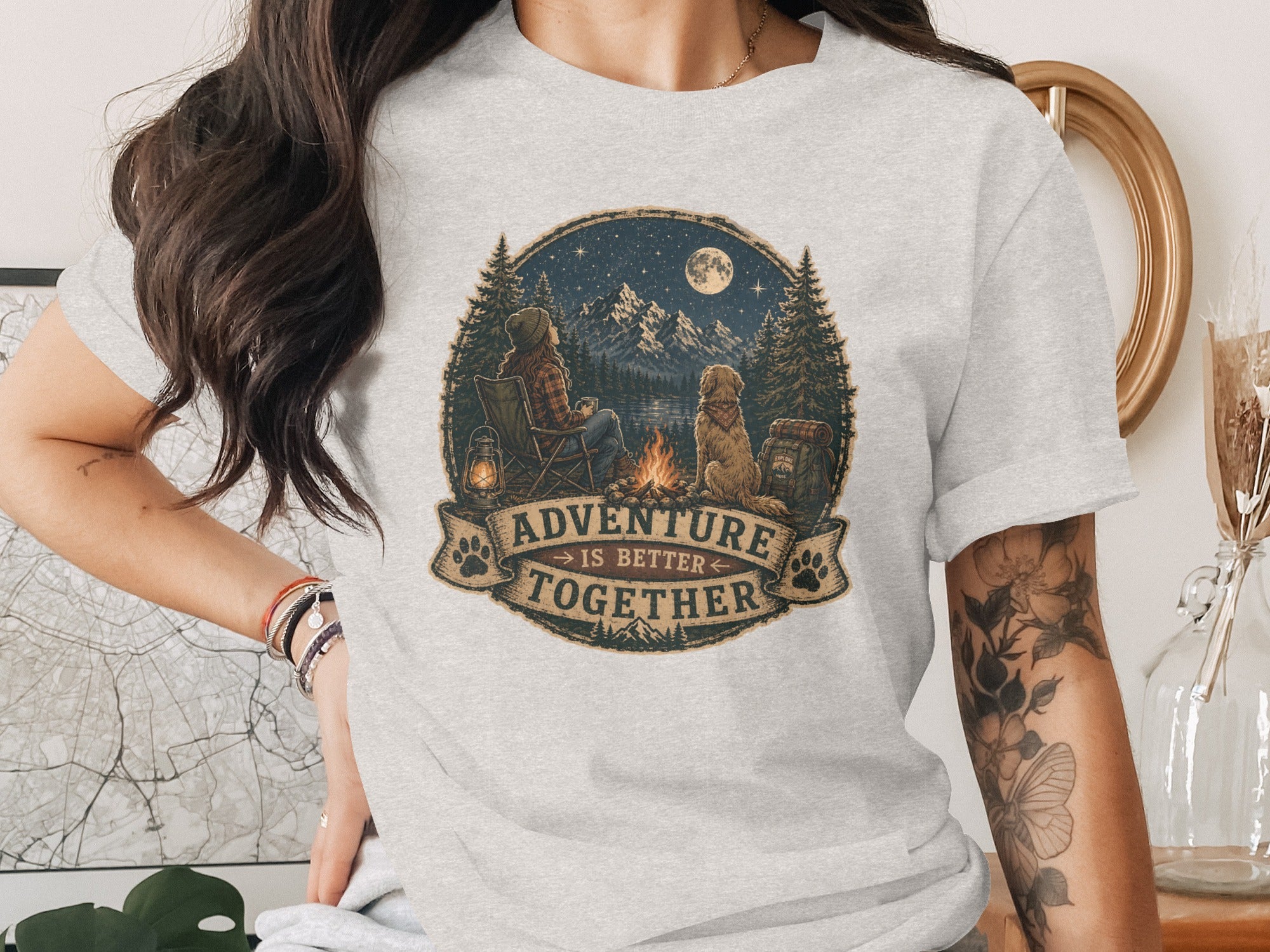 T-shirt design: Camper, dog, campfire, stars, mountains, and text "Adventure is Better Together".