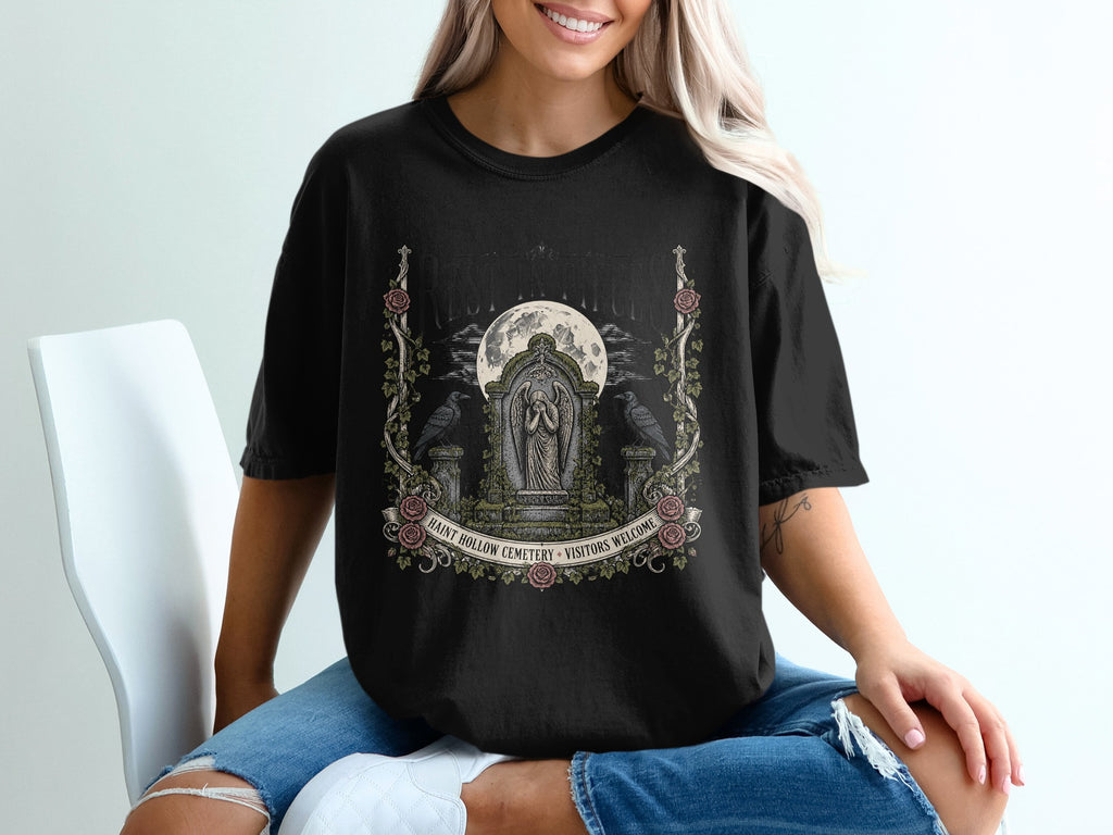 Black t-shirt with Haunt Hollow Cemetery graphic featuring a statue, moon, and crows.