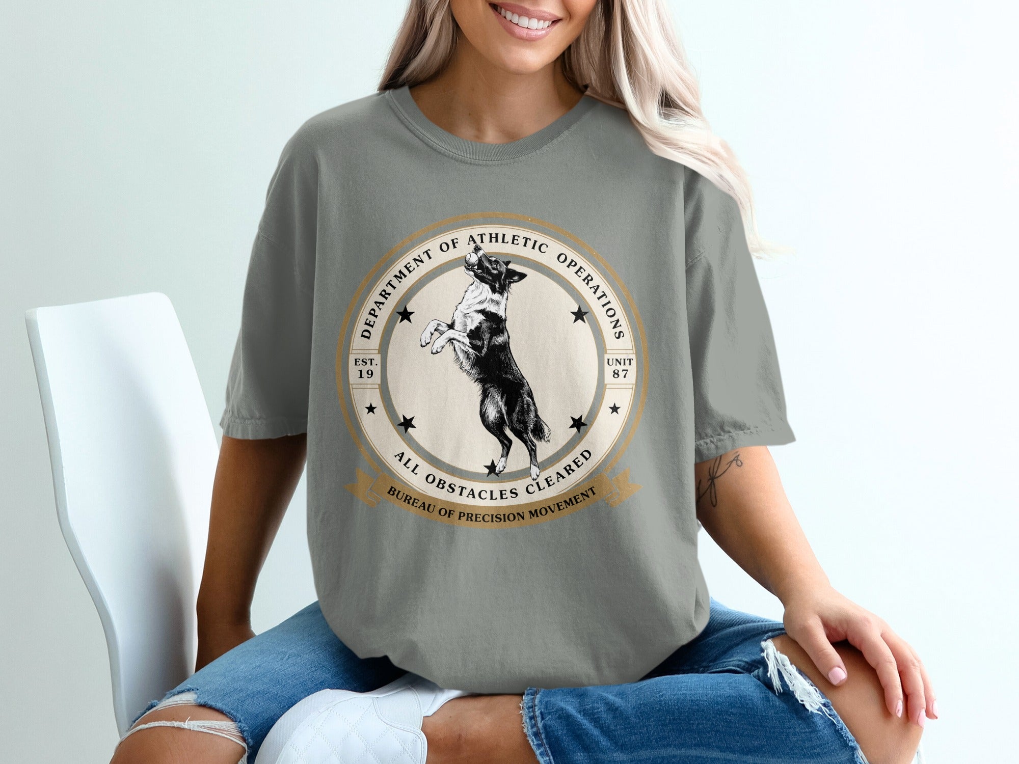 T-shirt with circular graphic of a dog, "Department of Athletic Operations," and "All Obstacles Cleared."