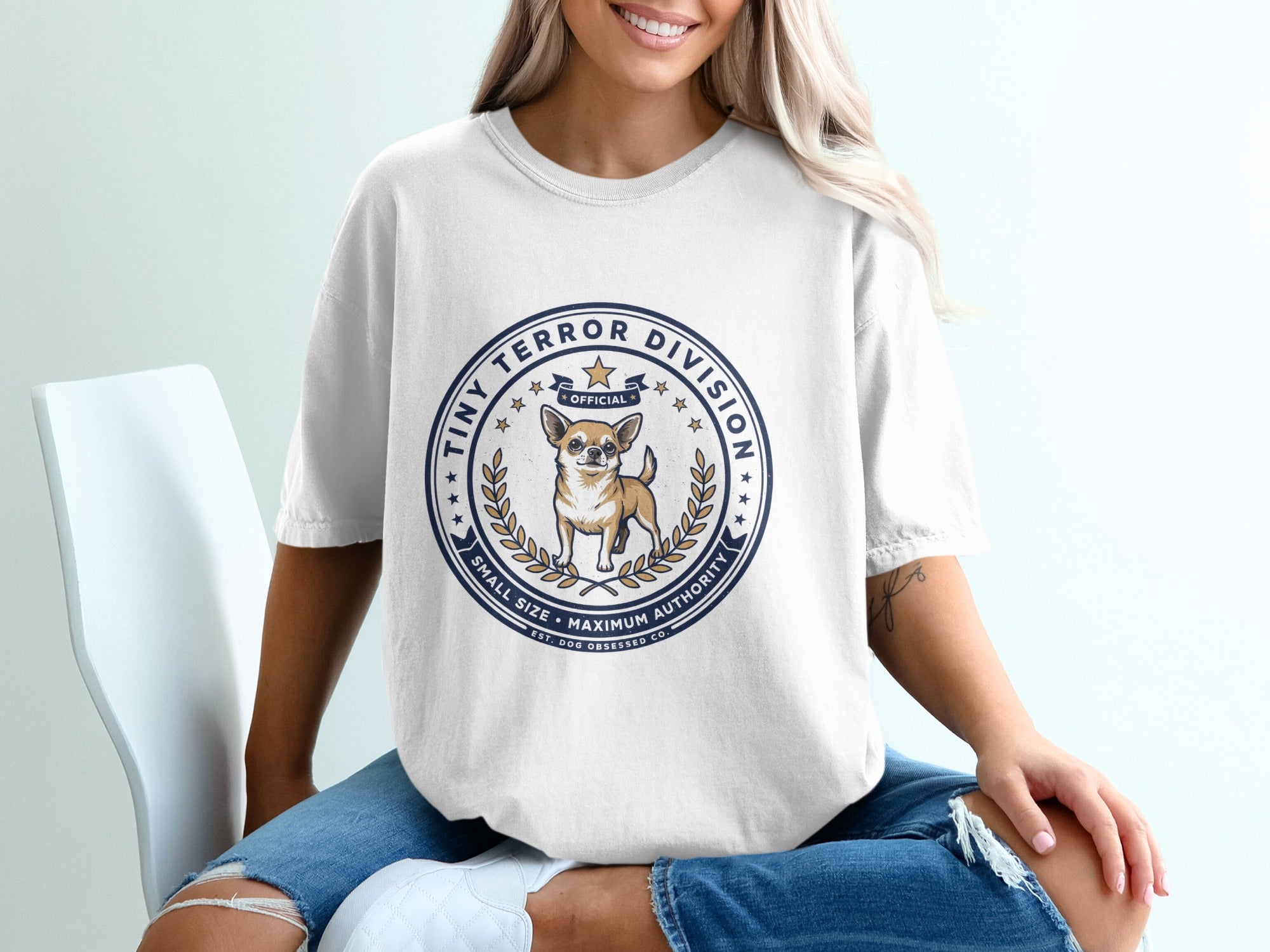 White t-shirt with a circular logo featuring a chihuahua and text "Tiny Terror Division".