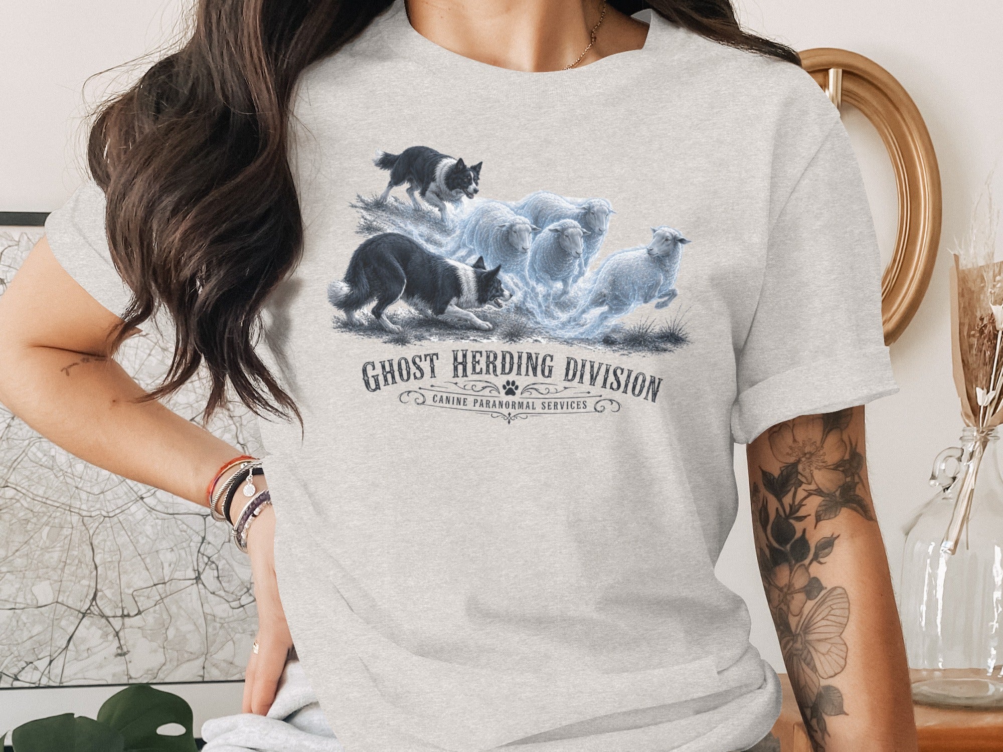 T-shirt graphic: dogs herding glowing sheep, "Ghost Herding Division Canine Paranormal Services".