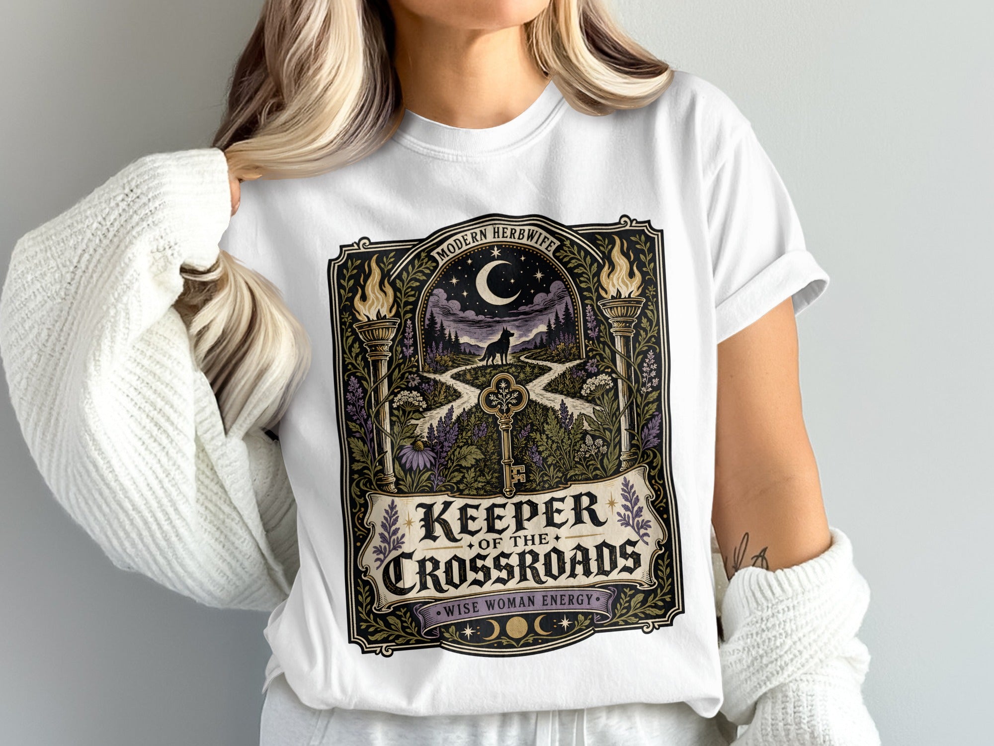 White t-shirt with "Keeper of the Crossroads" design featuring a wolf and key.