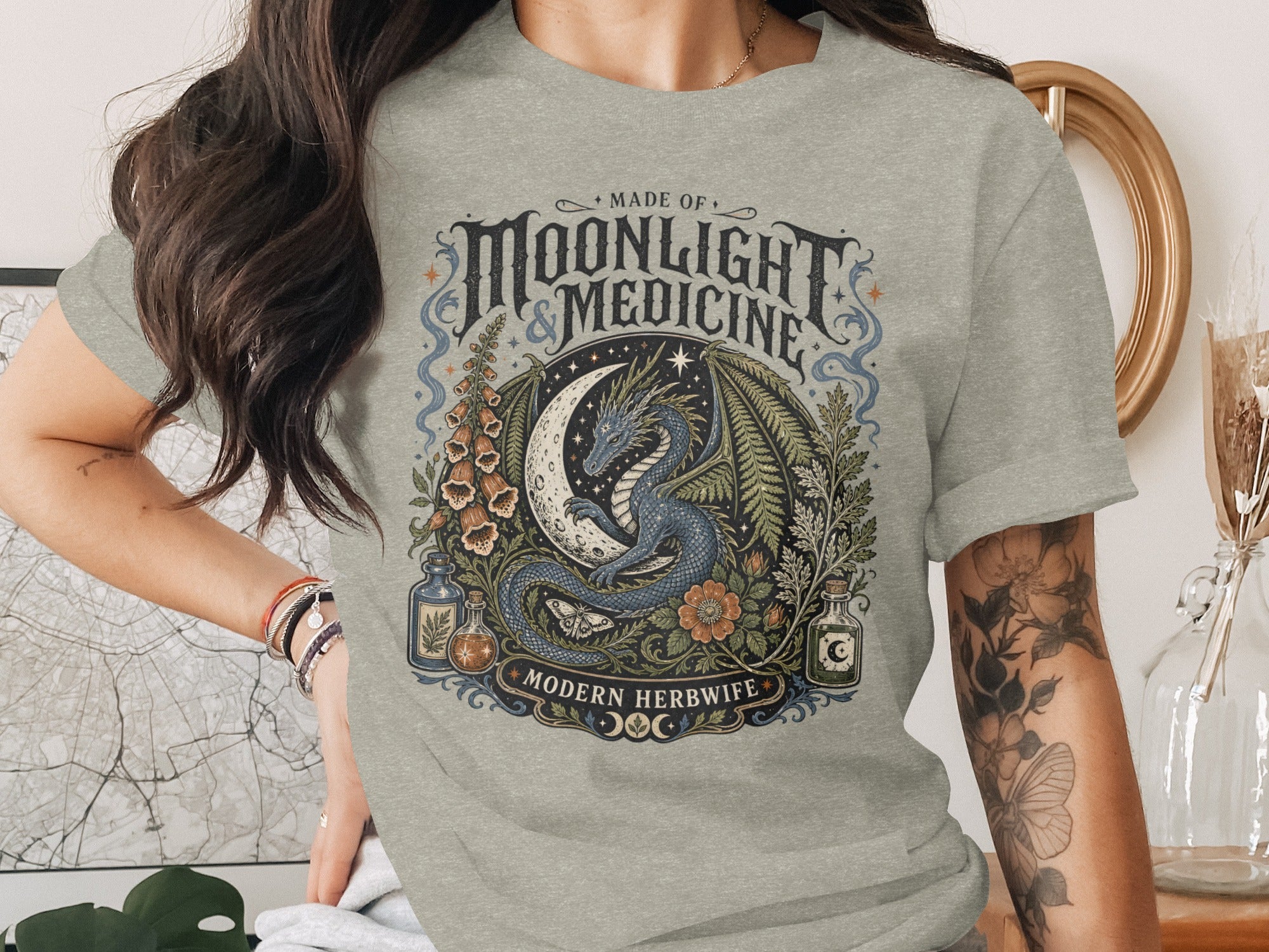 Gray t-shirt with "Made of Moonlight & Medicine Modern Herbwife" text and dragon design.