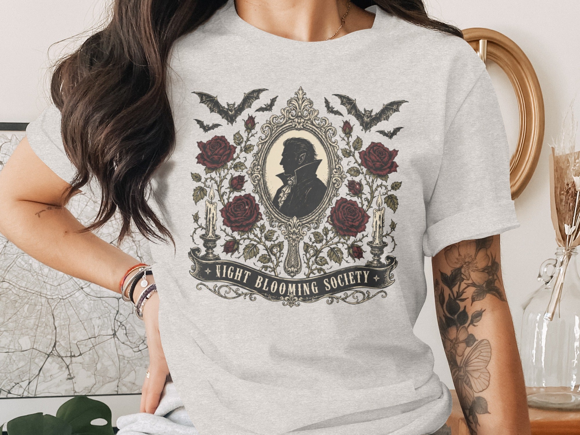 T-shirt with gothic design featuring vampire silhouette, roses, bats, candles, and text "NIGHT BLOOMING SOCIETY".