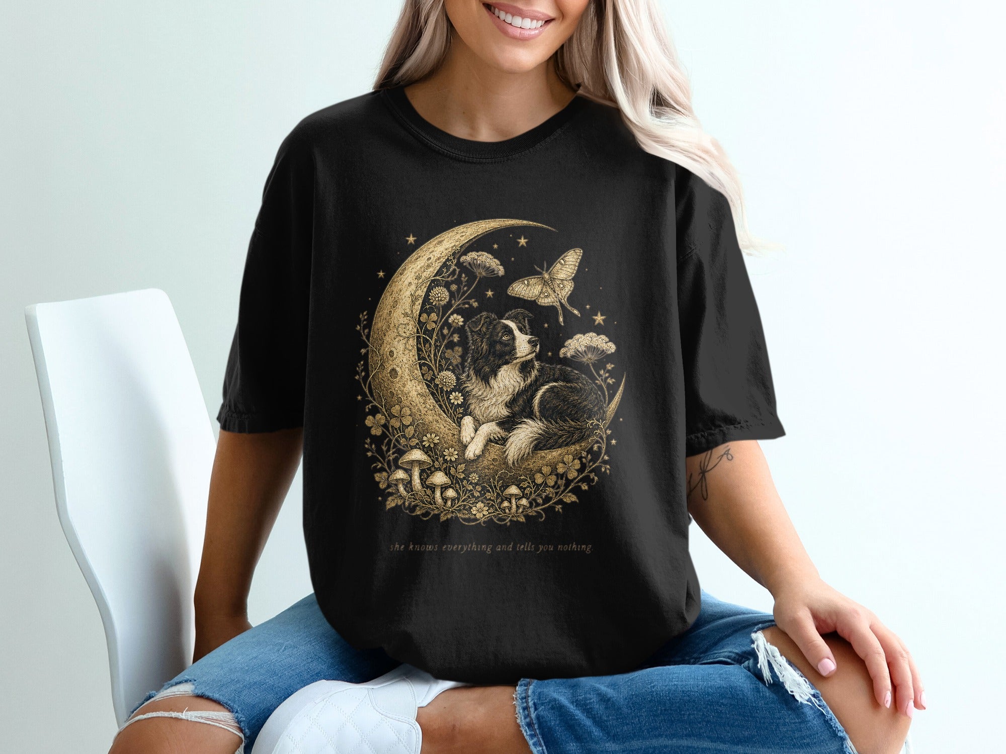 Black t-shirt with gold print of a dog on a moon with butterflies and mushrooms.