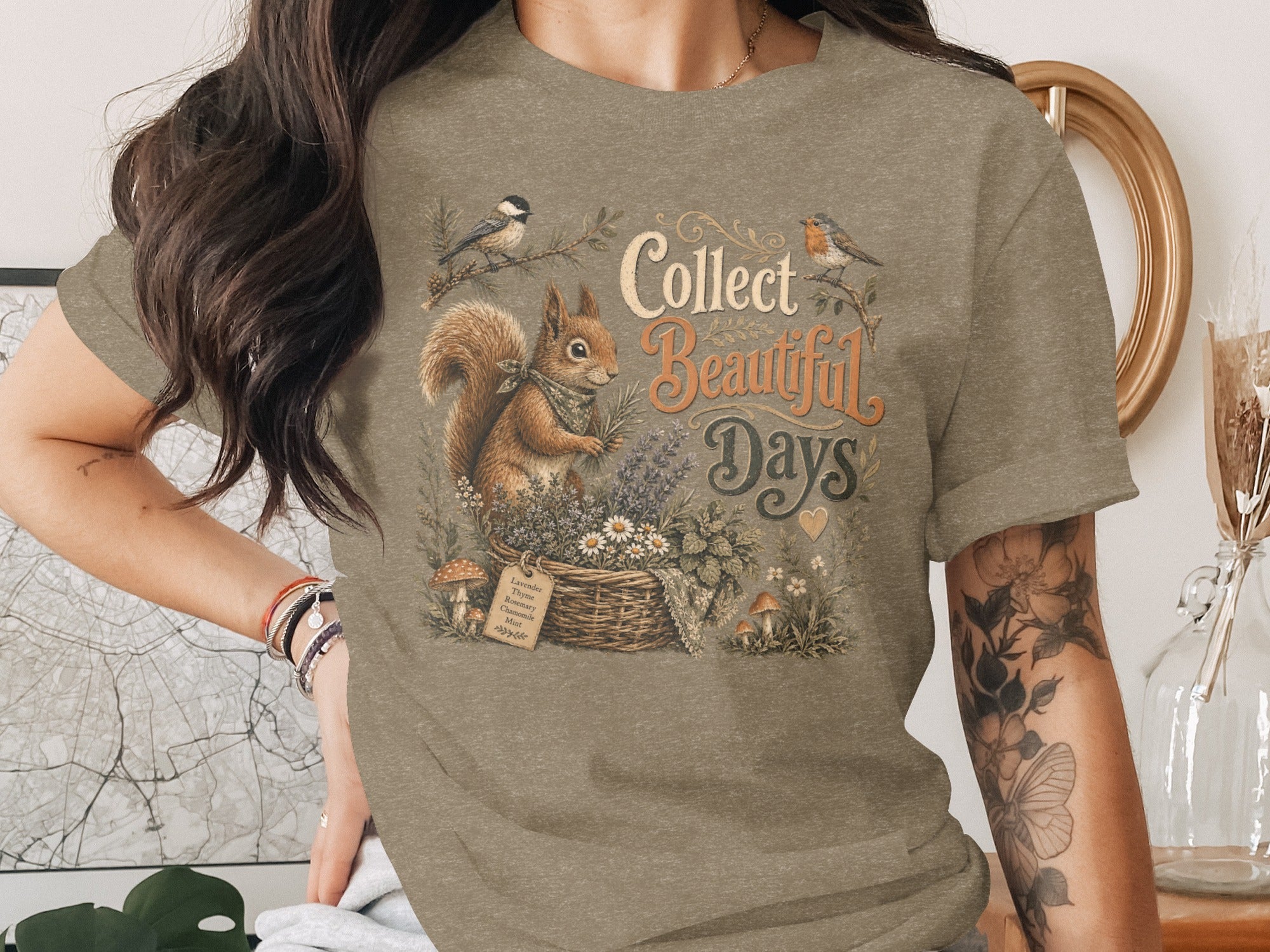 Squirrel and birds on shirt with text "Collect Beautiful Days". Plants and basket graphic.