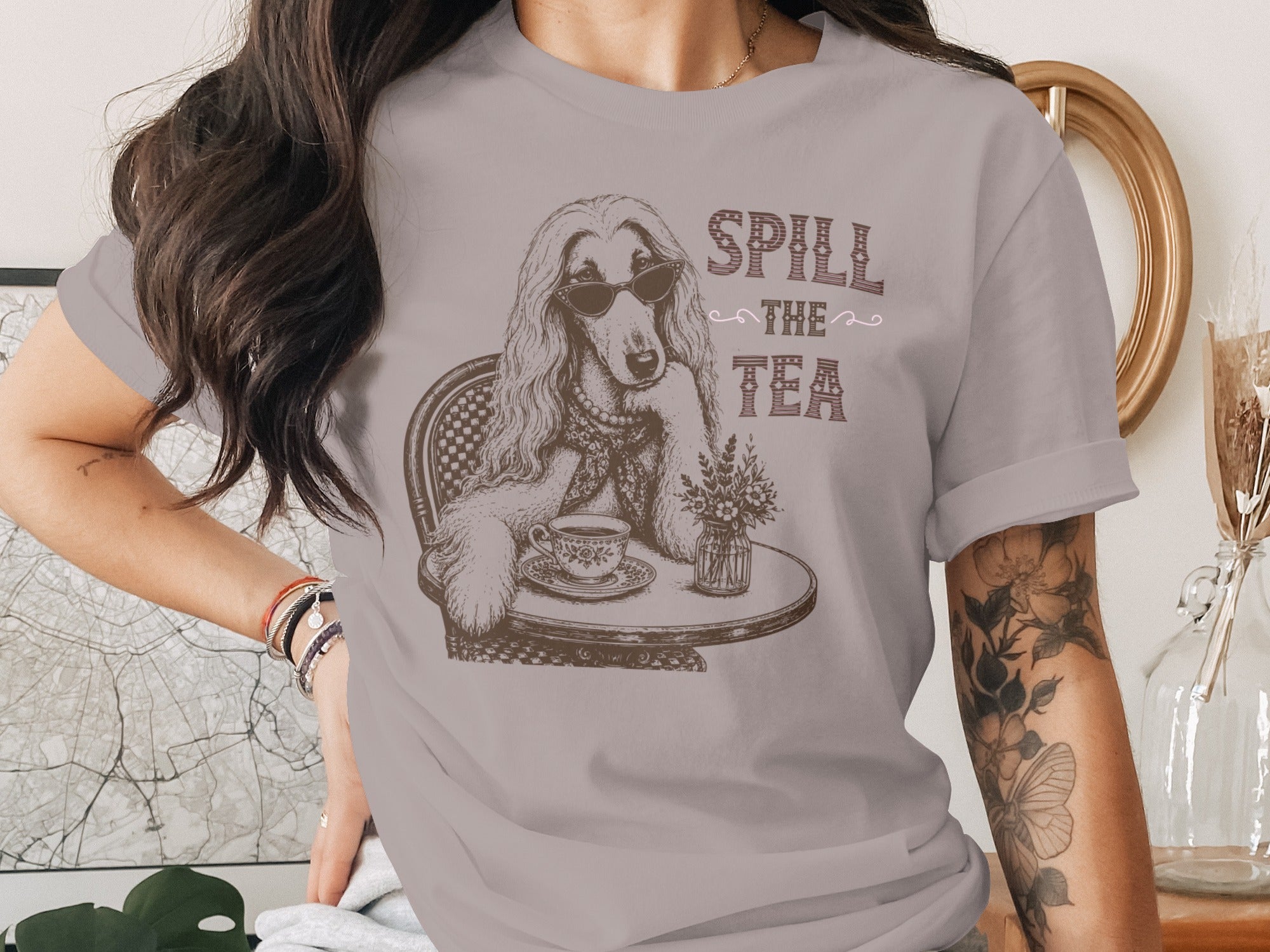 T-shirt graphic of a dog wearing sunglasses and drinking tea, text "Spill the Tea".