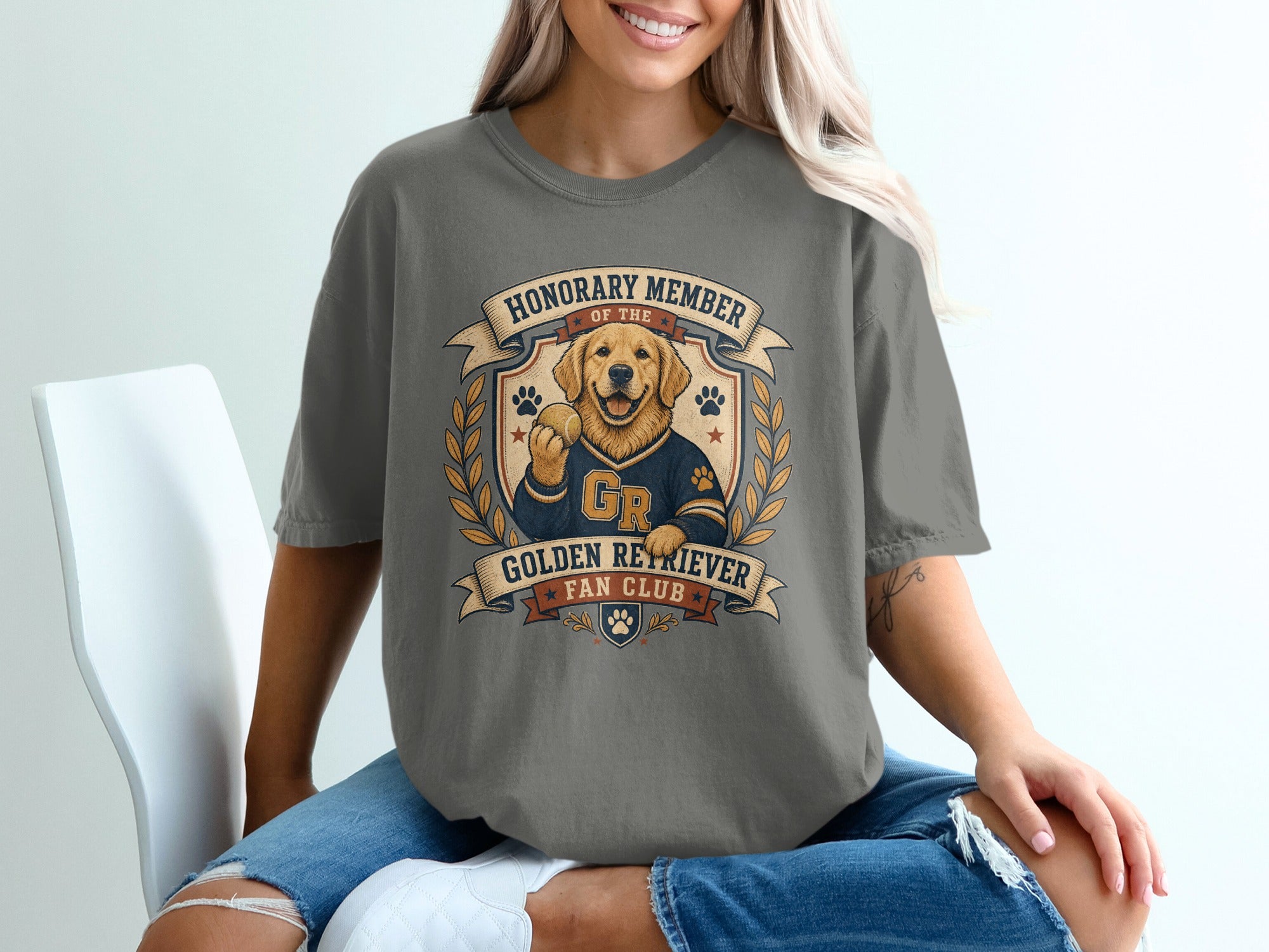 T-shirt graphic of a Golden Retriever wearing a jersey, holding a ball, and text "Honorary Member of the Golden Retriever Fan Club".