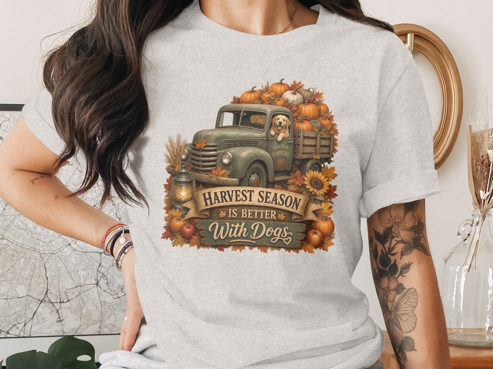 Gray t-shirt with a vintage truck overflowing with pumpkins and a dog, text "Harvest Season Is Better With Dogs".