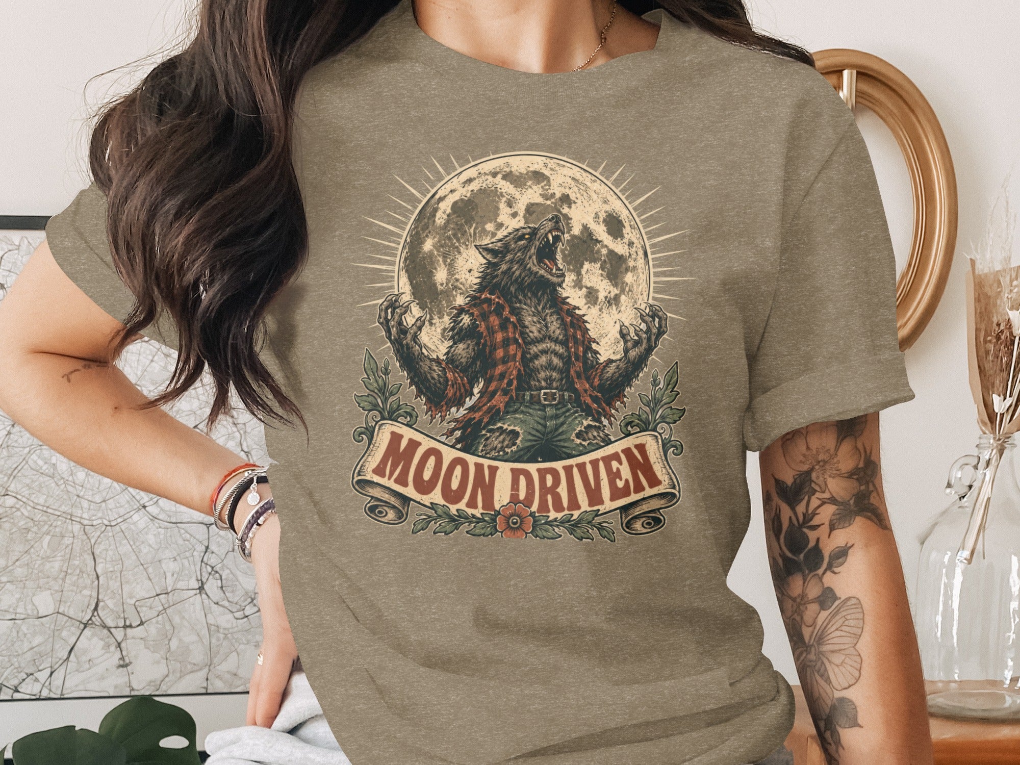 Werewolf howling at the moon with "Moon Driven" text on a t-shirt.