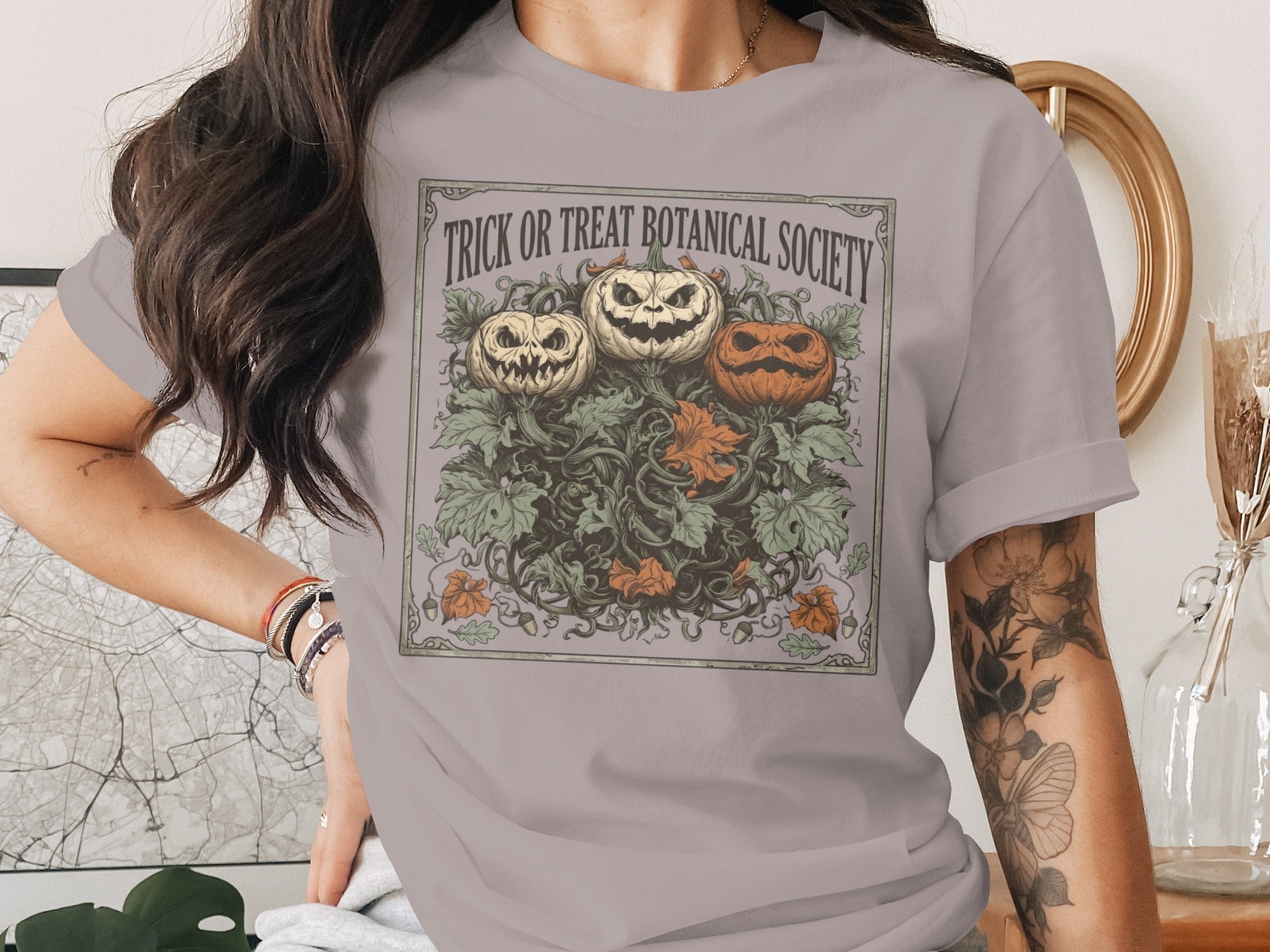 Three carved pumpkins surrounded by vines and leaves, with "Trick or Treat Botanical Society" text.